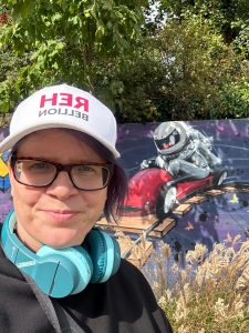 Eine weiteres Bild wo die Bloggerin vor einer bunt bemalten Wand mit Astronauten steht 