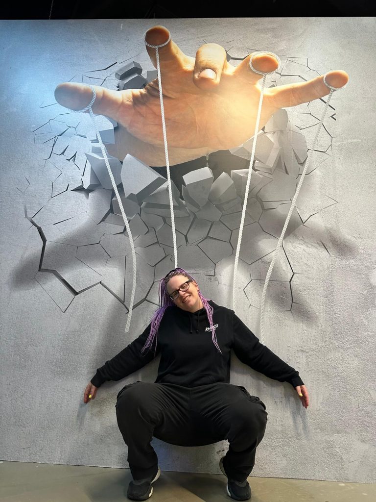 Ein Bild aus der Illusionswelt, wo die Bloggerin vor einer Wand steht. Wo es aussieht als würde sie an Fäden hängen, die von einer fremden Hand  geführt wird.