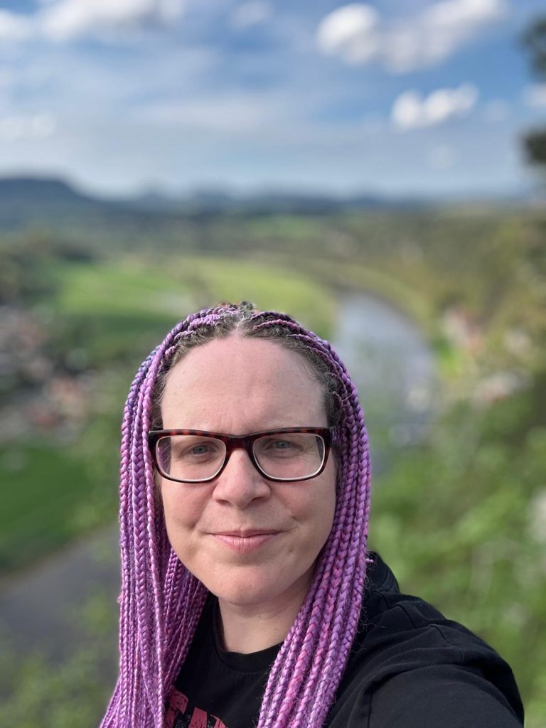 Die Bloggerin steht oben auf einem Berg und das Tal ist ein klein wenig erkennbar