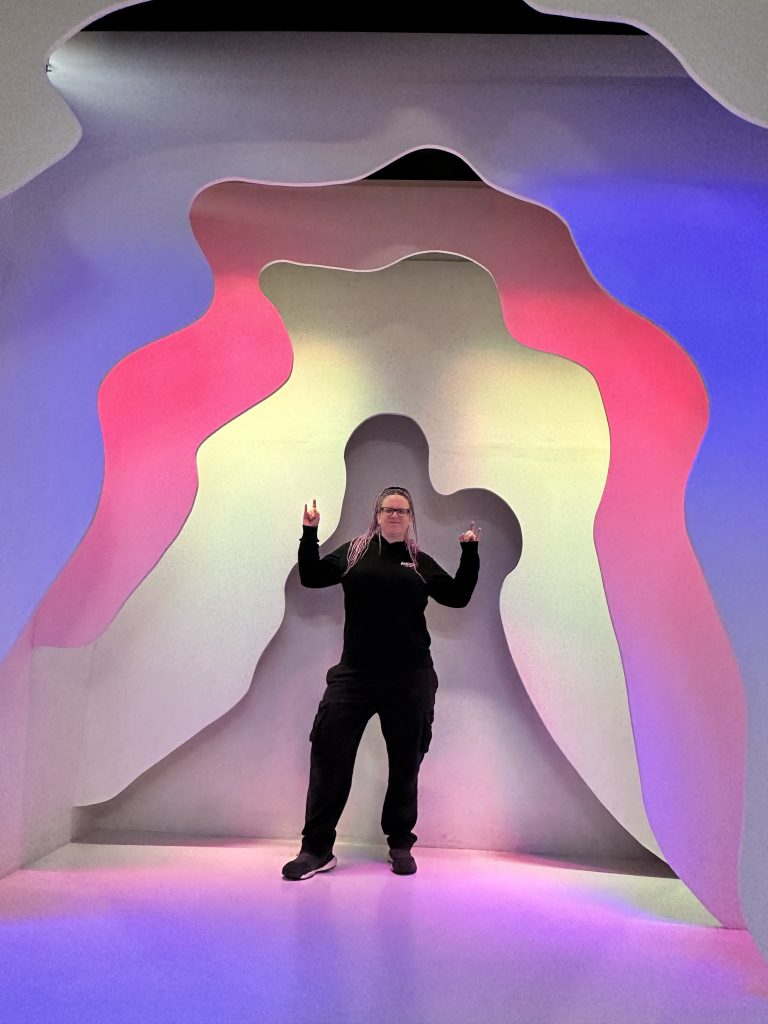 Ein Illusionshintergrund mit mehreren Wänden und Farben. Die Bloggerin steht in der Mitte