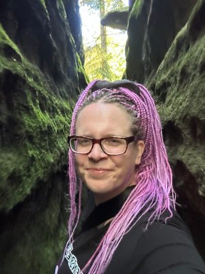 Bloggerin Nena steht in einem Felsenlabyrinth zwischen zwei hohen Felsen am helligen Tage