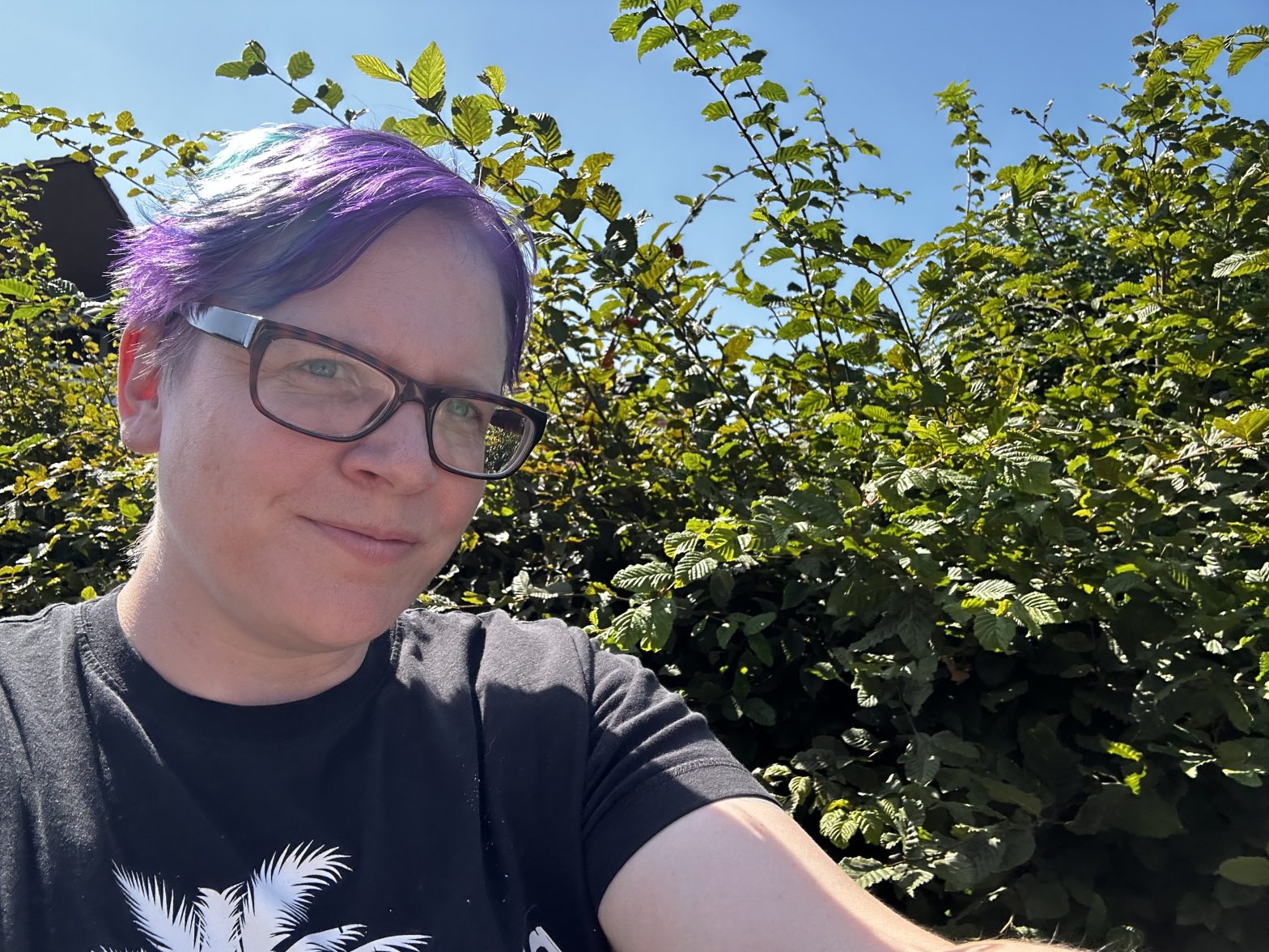 Bloggerin Nena vorbei laufend an einer Hecke bei einem schönen sonnigen Tag